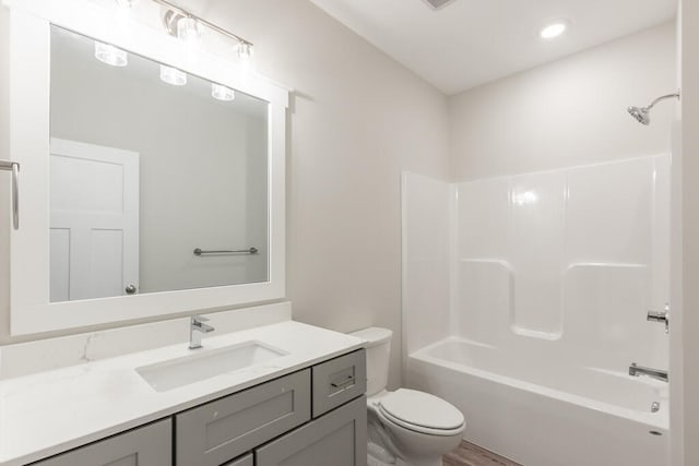 full bathroom with toilet, wood-type flooring, large vanity, and bathtub / shower combination