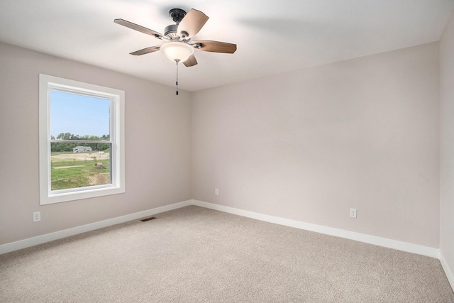 carpeted empty room featuring a healthy amount of sunlight and ceiling fan