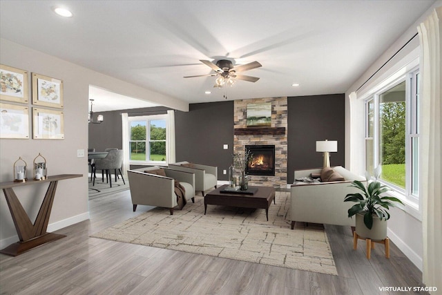 living room with hardwood / wood-style flooring, ceiling fan, a wealth of natural light, and a fireplace