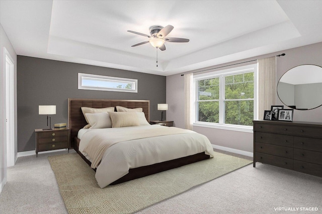 bedroom featuring carpet floors, a raised ceiling, and ceiling fan