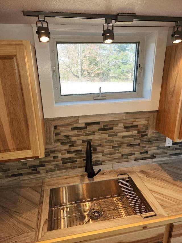 interior details with backsplash and a textured ceiling