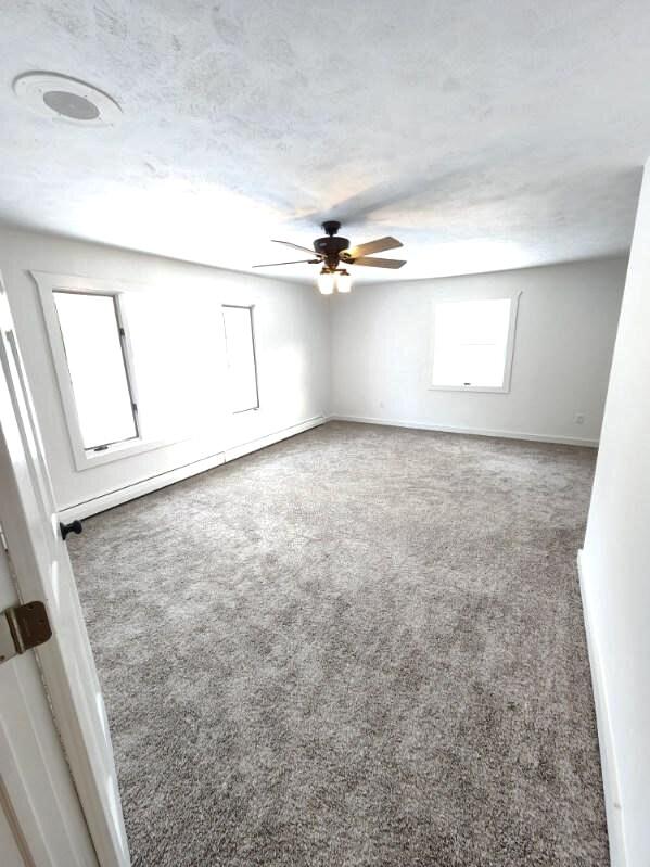 carpeted spare room with ceiling fan