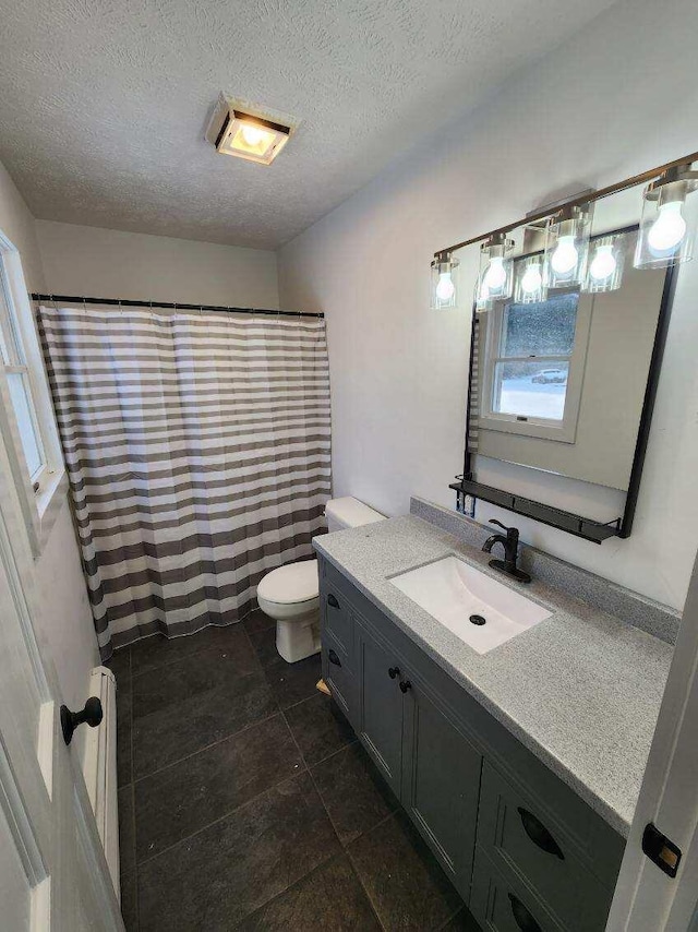 bathroom with toilet, a textured ceiling, tile flooring, and vanity