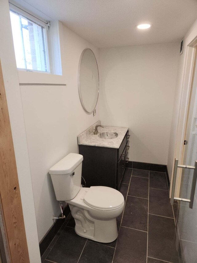 bathroom featuring vanity, tile floors, and toilet