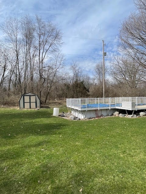 view of yard with a wooden deck and a shed