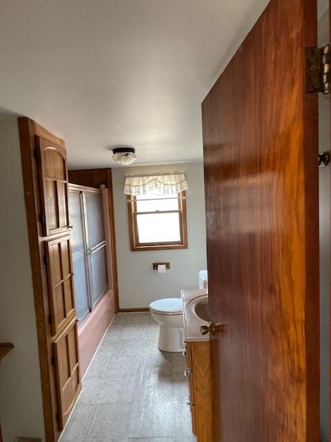 full bathroom with shower / bath combination with glass door, toilet, tile flooring, and vanity