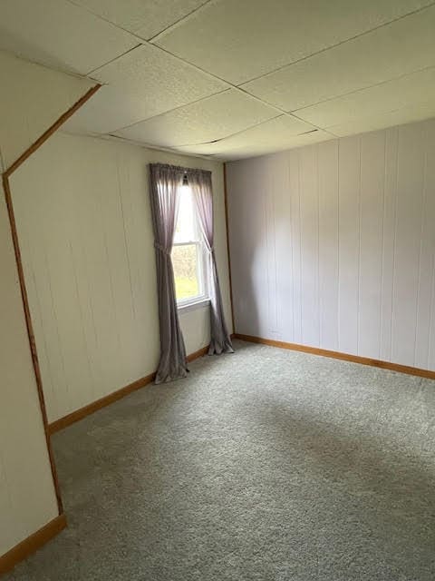 unfurnished bedroom with carpet floors and a drop ceiling