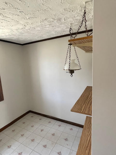 interior space with light tile flooring and a textured ceiling