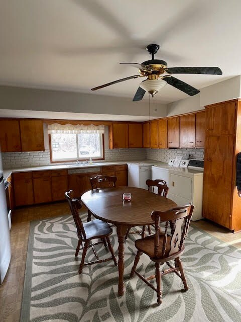 dining area featuring light hardwood / wood-style floors, washer and clothes dryer, and ceiling fan