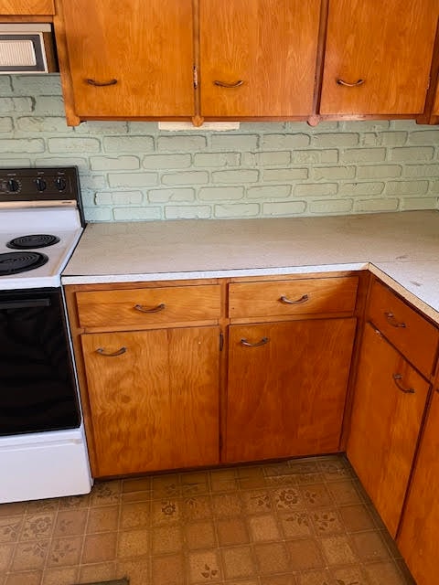 kitchen with electric stove and light tile floors