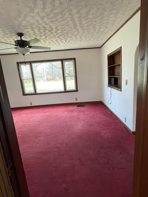 carpeted spare room featuring ceiling fan