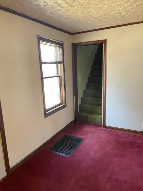 carpeted empty room with a textured ceiling