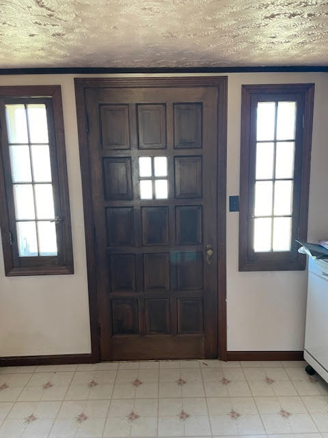 tiled foyer with a textured ceiling