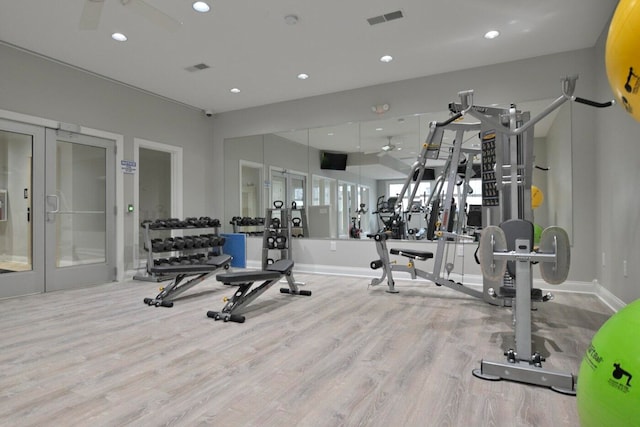 exercise room with light hardwood / wood-style flooring and french doors