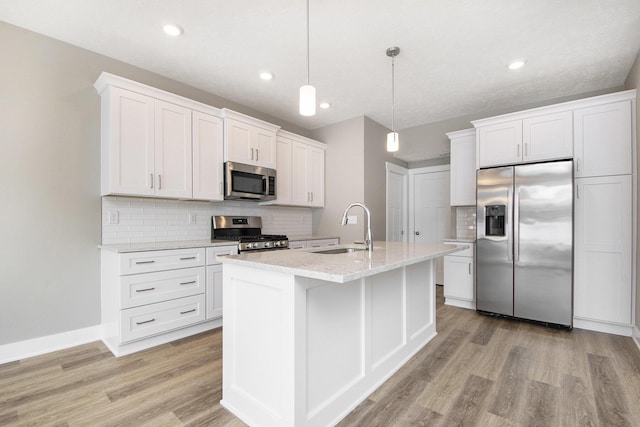 kitchen featuring sink, stainless steel appliances, hanging light fixtures, and white cabinets