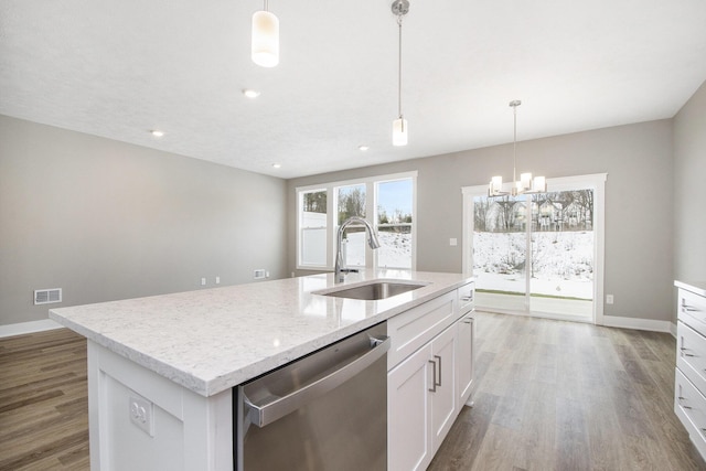 kitchen with sink, white cabinetry, hanging light fixtures, stainless steel dishwasher, and an island with sink