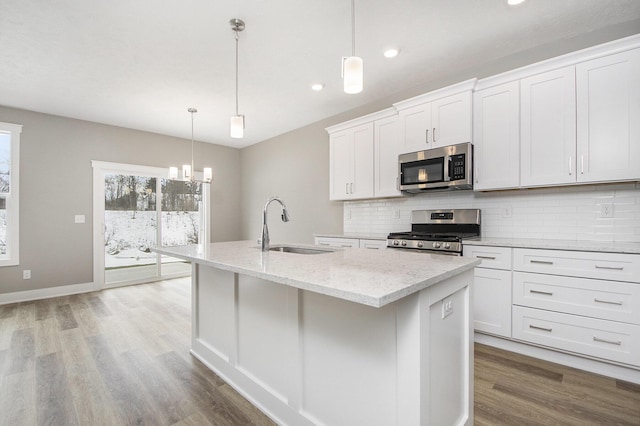 kitchen featuring an island with sink, appliances with stainless steel finishes, sink, and white cabinets