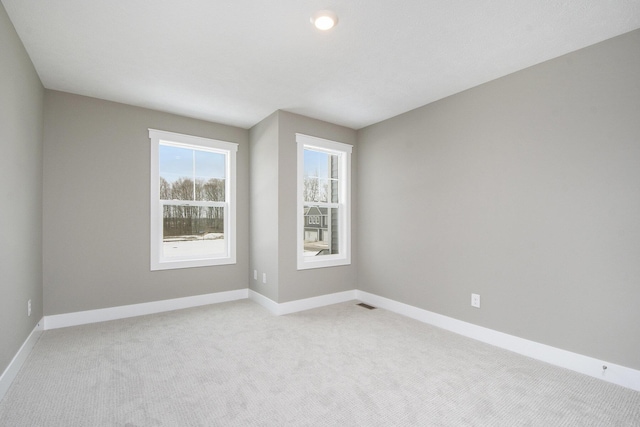 spare room featuring light colored carpet