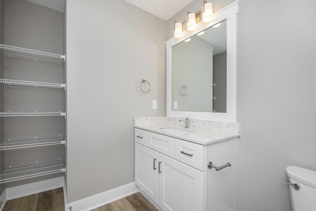 bathroom with hardwood / wood-style flooring, vanity, and toilet