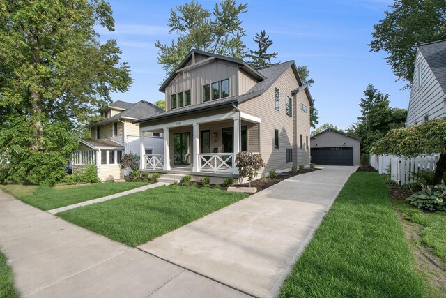 view of front of house featuring a garage, a porch, an outdoor structure, and a front yard