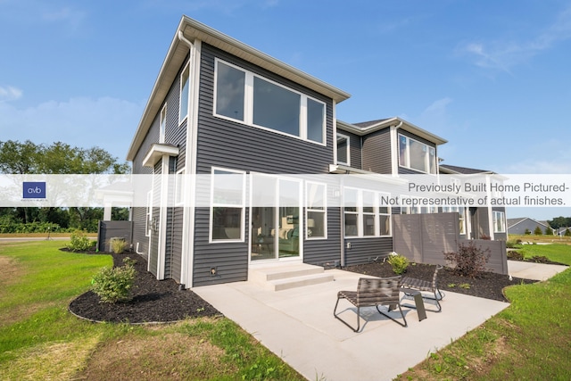 back of house featuring a lawn and a patio