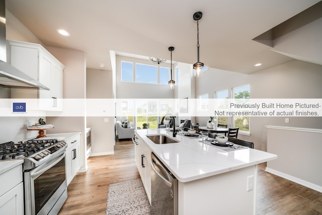 kitchen with a healthy amount of sunlight, a kitchen island with sink, sink, and stainless steel appliances