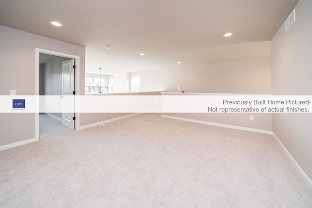 carpeted empty room with a chandelier