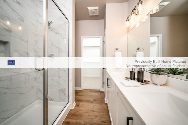 bathroom featuring hardwood / wood-style floors, vanity, and an enclosed shower