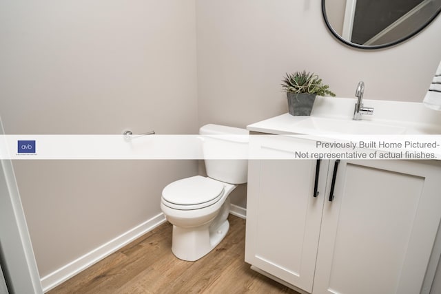 bathroom with hardwood / wood-style floors, vanity, and toilet