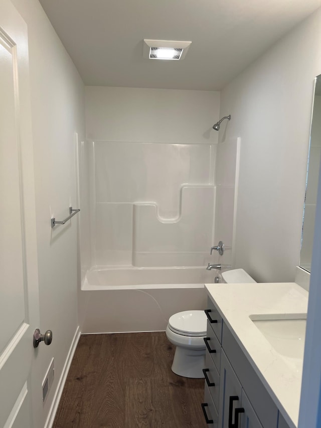 full bathroom featuring washtub / shower combination, vanity, hardwood / wood-style flooring, and toilet