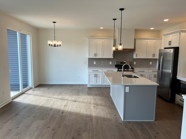 kitchen featuring stainless steel appliances, hardwood / wood-style flooring, white cabinetry, and pendant lighting