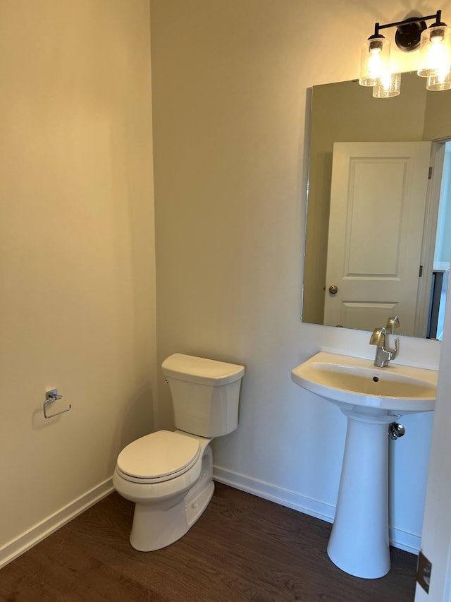 bathroom with hardwood / wood-style floors and toilet