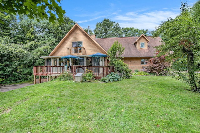 back of property with a wooden deck and a yard