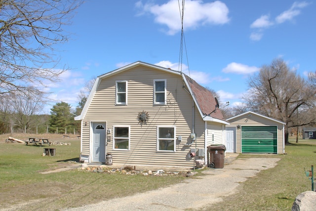 view of front of home with an outdoor structure, a front yard, and a garage