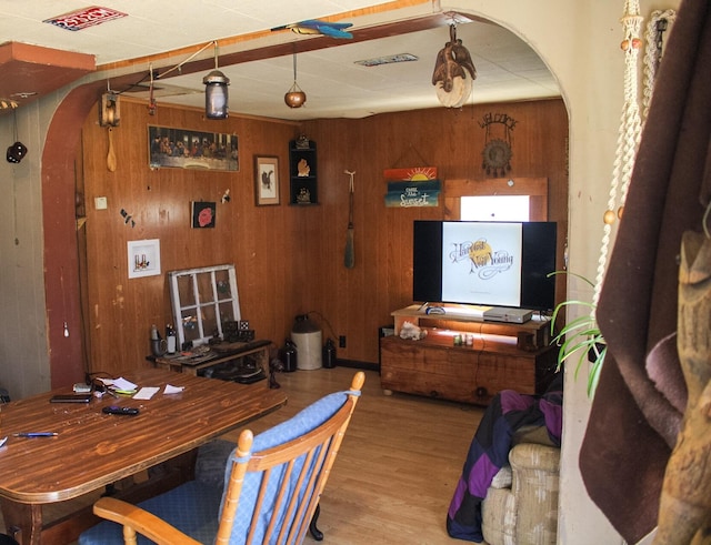 dining area with light hardwood / wood-style floors and wood walls