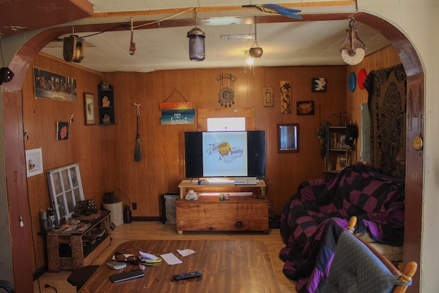 living room featuring light wood-type flooring and wood walls