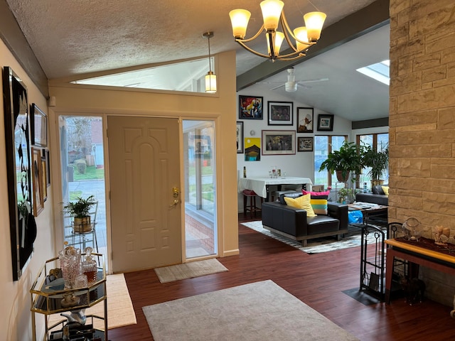 entryway with dark hardwood / wood-style floors, lofted ceiling with beams, ceiling fan with notable chandelier, and a healthy amount of sunlight