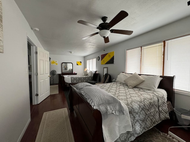 bedroom featuring ceiling fan, multiple windows, and dark wood-type flooring