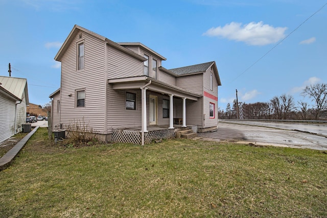 view of front of property with a front yard and central air condition unit