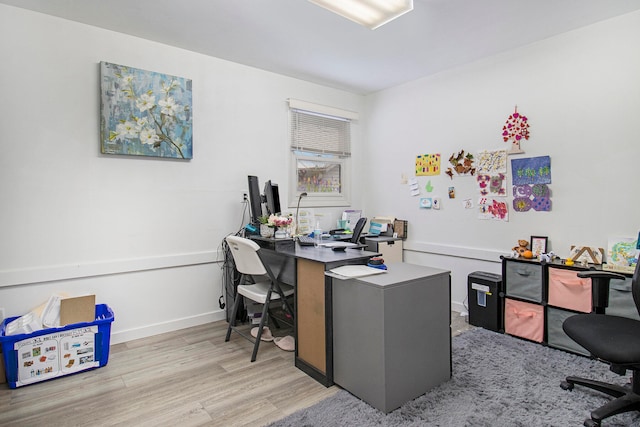 home office with light hardwood / wood-style floors