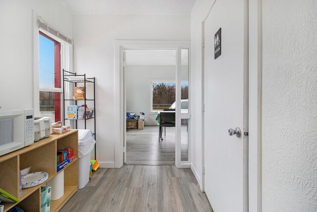 hallway with light hardwood / wood-style flooring