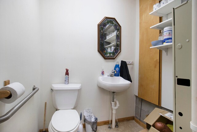 bathroom with toilet and tile floors