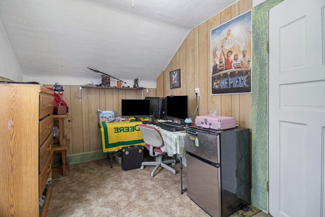 carpeted office space featuring lofted ceiling, a textured ceiling, and wooden walls