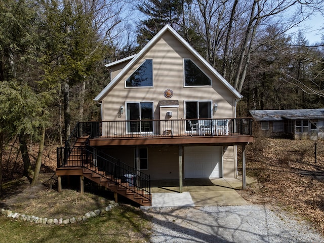 back of property featuring a wooden deck and a garage