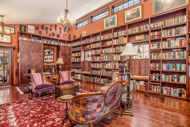 living area featuring hardwood / wood-style floors, plenty of natural light, a notable chandelier, and vaulted ceiling