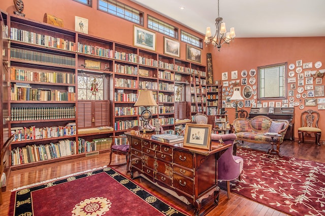 office space with an inviting chandelier, vaulted ceiling, and wood-type flooring