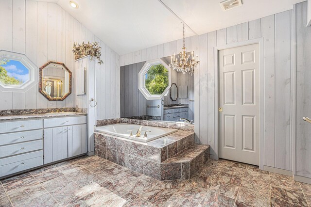 bathroom with tile patterned floors, wood walls, and vanity