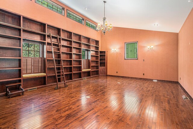 interior space with high vaulted ceiling, a chandelier, and hardwood / wood-style floors