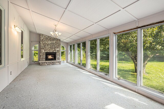 interior space with vaulted ceiling, a fireplace, and an inviting chandelier