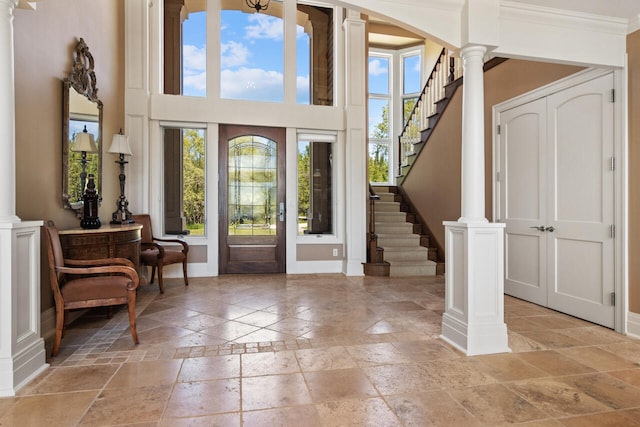 entryway featuring crown molding and ornate columns